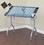 Studio Designs 13220 Folding Adjustable Top Craft Station with Supply Storage in Silver/Blue Glass